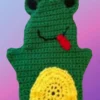 Green crocheted frog hand puppet with black eyes, smiling mouth and yellow belly