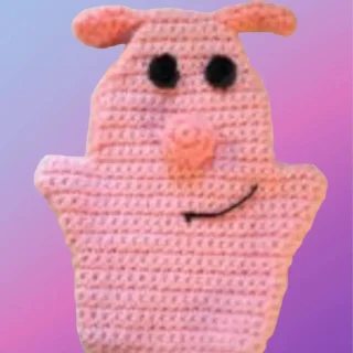 Pink crocheted pig hand puppet with floppy ears, round snout and smiling face