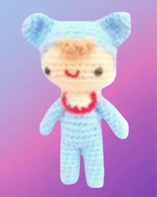 Crochet baby doll with blue outfit, yellow skirt and embroidered facial details