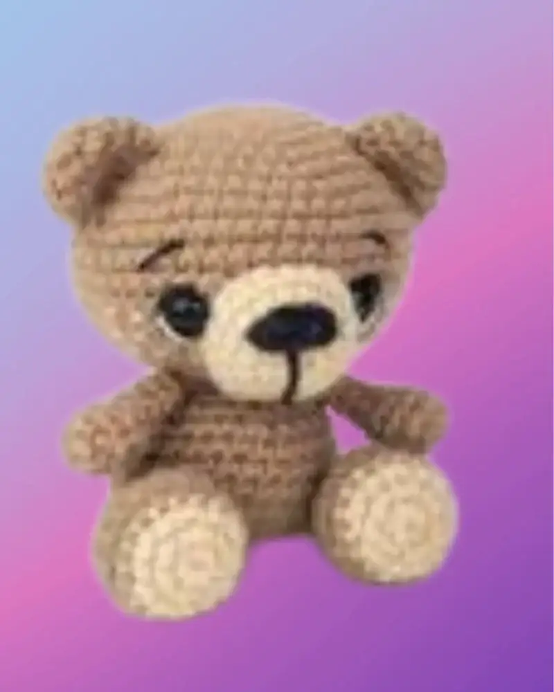 Crocheted Benji the Bear woodland critter sitting with tan muzzle and paws
