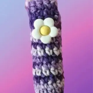 Crocheted lip balm and lipstick holder with attached top and decorative flower button