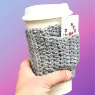 Crocheted coffee cup cozy with small front pocket