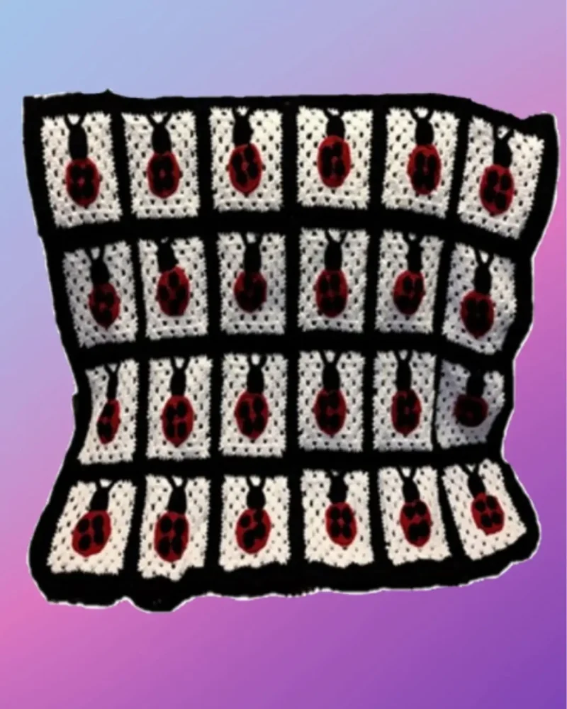 Handmade crochet baby blanket with individual ladybug designs sewn onto crocheted squares