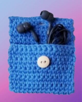 Blue crocheted mini pouch with button closure holding earbuds and cord.