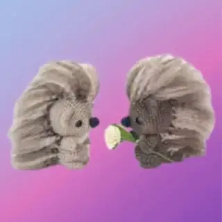 Crocheted Pepper and Poe woodland porcupines with fluffy quills, Poe holding a flower