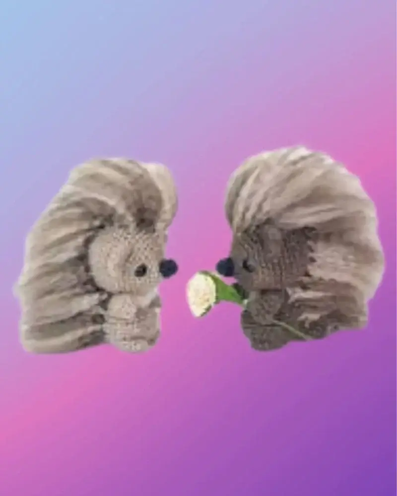 Crocheted Pepper and Poe woodland porcupines with fluffy quills, Poe holding a flower