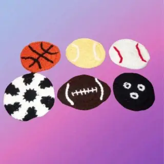Set of six crocheted sports ball coasters with basketball, tennis, baseball, soccer, football and bowling designs