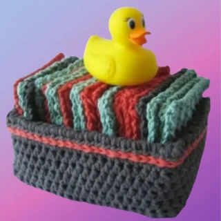 Handmade crochet washcloths arranged in a matching crochet basket